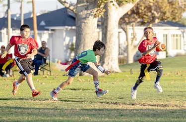Kids playing flag football at park
