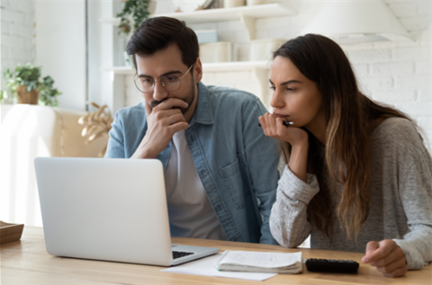 Couple absorbed in information on laptop