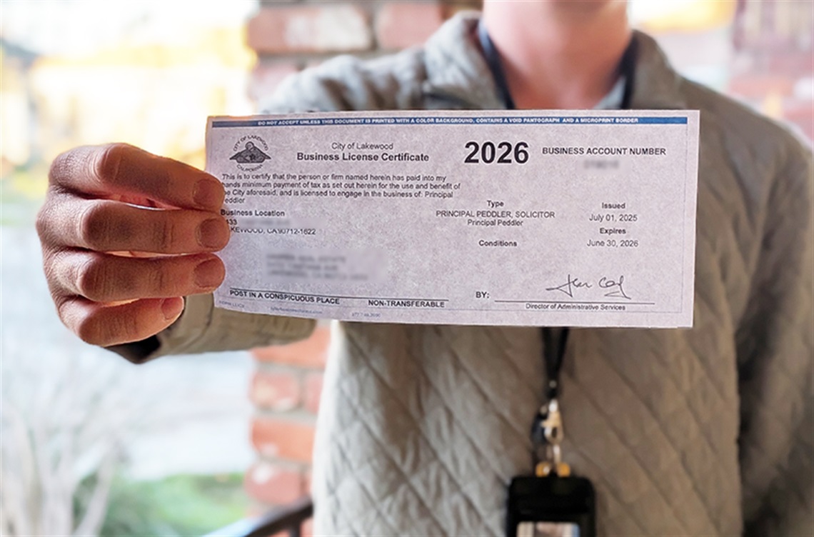 Man holding solicitor permit at doorway