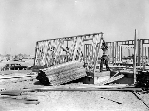 Three men raising a wall frame