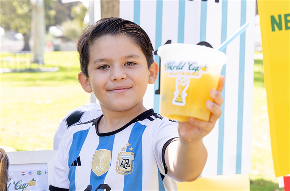 Boy offering cup of lemonade