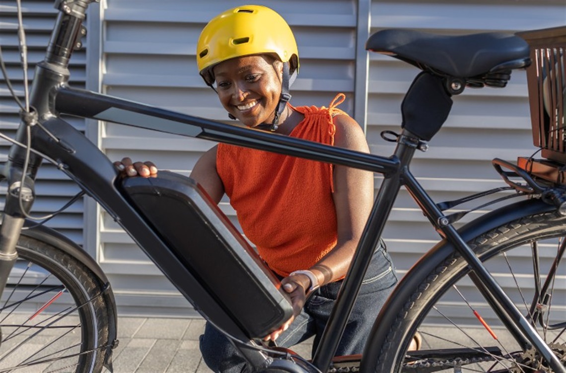 Rider kneeling next to e-bike