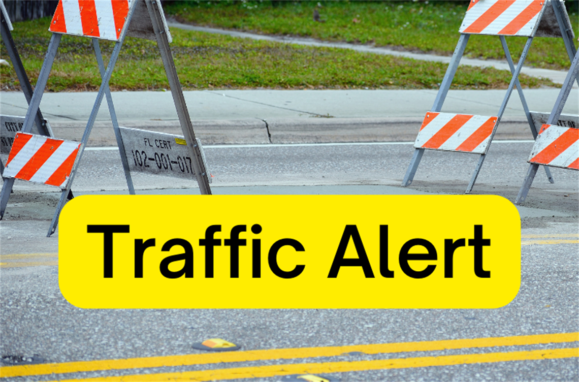 Street with road blocks and text Traffic Alert