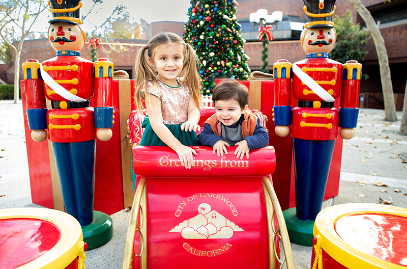 Kids in sleigh in front of Civic Center holiday tree