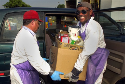Workers carrying box of hazardous waste items