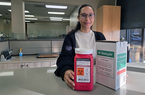 City employee at counter with sharps container